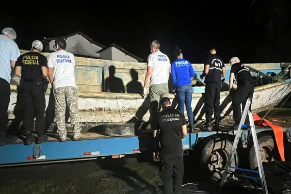 Imagem colorida de agentes da PF com embarcação clandestina - Metrópoles