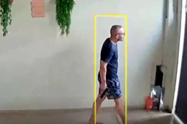 Foto colorida de homem com arma na garagem de residência em Limeira.
