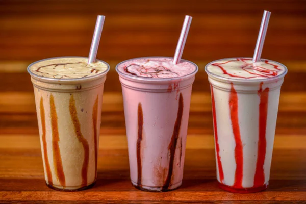 Imagem colorida de três milkshakes