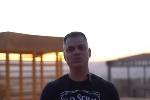 Homem com cara séria em ambiente aberto e com sombra