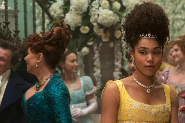 Foto colorida de Ruby Barker em Bridgerton, usando vestido amarelo e com tiara no cabelo - Metrópoles