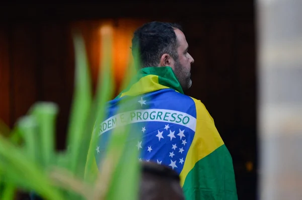 Foto de um homem de costas com a bandeira do Brasil