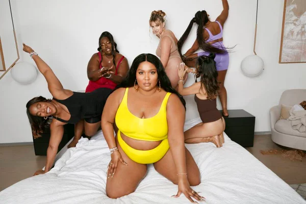 Lizzo e outras mulheres em cama usando lingeries