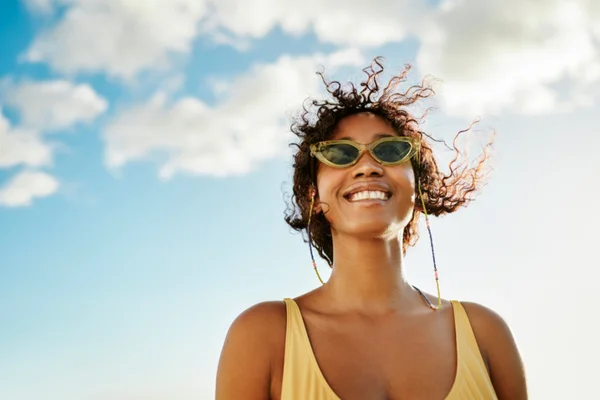 Mulher sorrindo com óculos de sol - Metrópoles