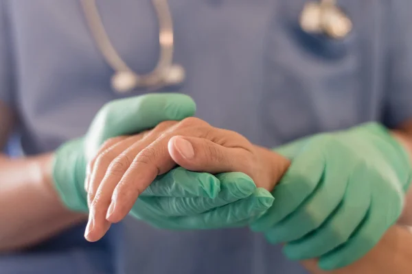 Cirurgião médico segurando mão da pessoa em hospital - Metrópoles
