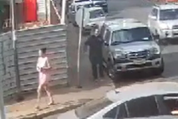 Imagem colorida mostra mulher atravessando rua