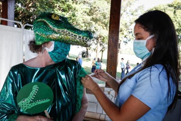 Mulher é vacinada contra Covid fantasiada de jacaré