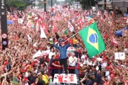 Lula segura Constituição e Bandeira do Brasil enquanto canta o Hino na Paulista