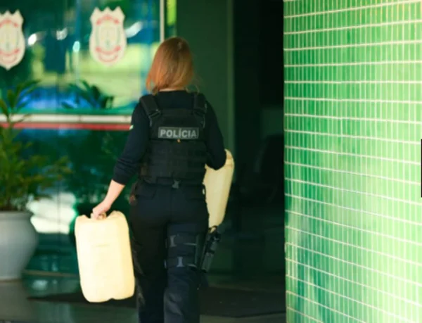 polícia carregando galão