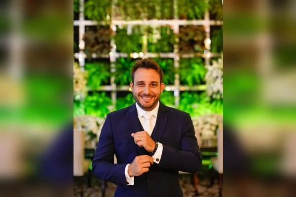 Fotografia colorida mostra homem de terno com flores ao fundo - Rafael Lopes é o novo reitor do Ceub