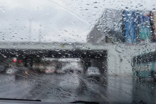 Pingos de chuva no para-brisa de um carro