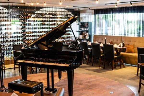 Foto colorida de piano de cauda em salão