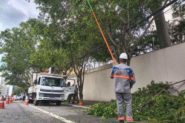 Imagem colorida mostra funcionários da Enel após apagão em SP. Metrópoles