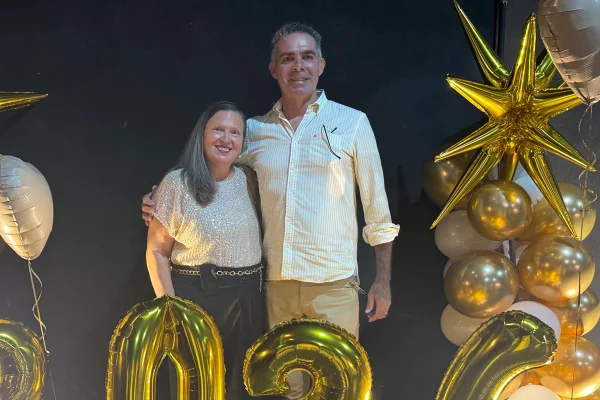 Foto colorida de casal se abraçando e sorrindo para foto - Metrópoles.