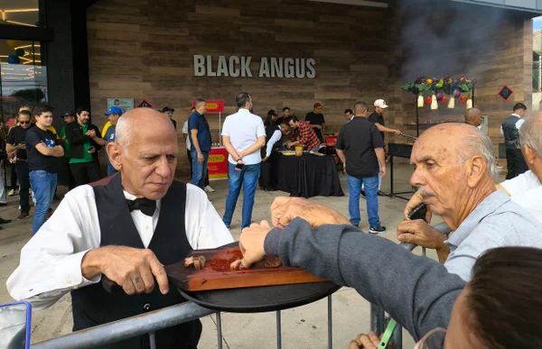 Imagem colorida de homem servindo churrasco - Metrópoles