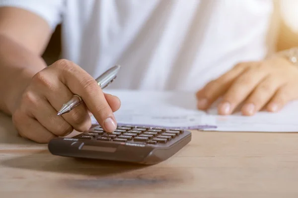 Pessoa fazendo calculos com o auxilio de uma calculadora
