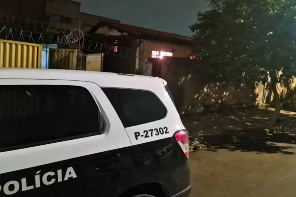 Foto colorida de viatura da Polícia Civil em frente à residência onde cozinheira foi morta pelo ex-amante.