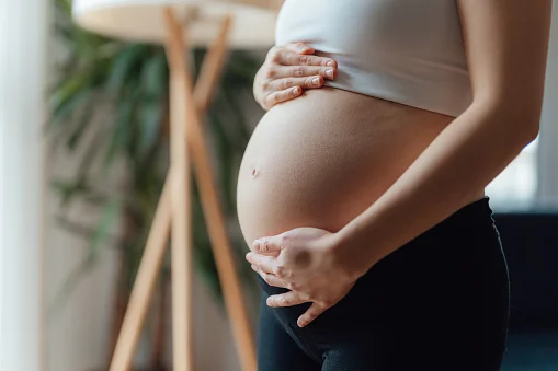 Mulher grávida com as mãos na barriga