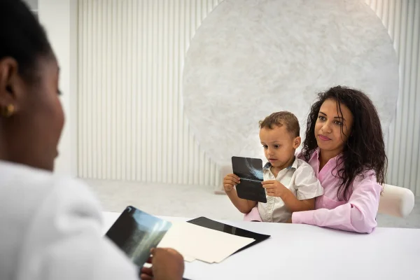 Mãe e filho em consulta com médica- Metrópoles