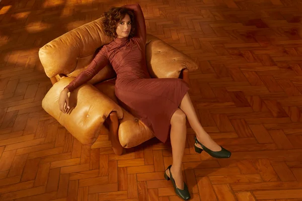 campanha com Camila Pitanga sentada em poltrona
