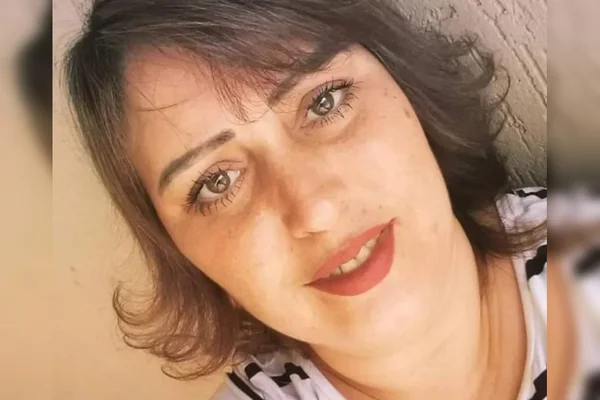 Mulher branca com cabelo curto e batom na boca fazendo selfie