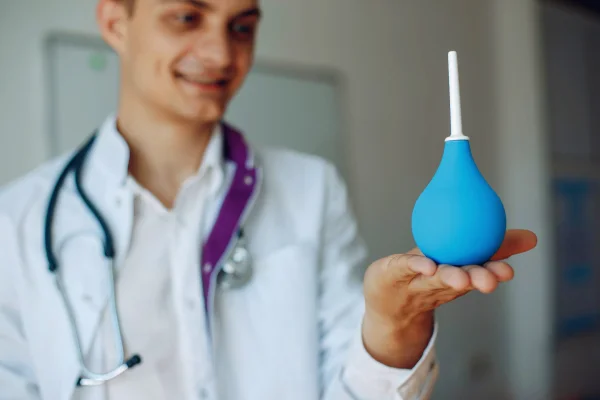 Foto colorida de médico segurando ducha higiênica