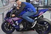 Cristian Cravinhos posa em uma loja de motos para as redes sociais