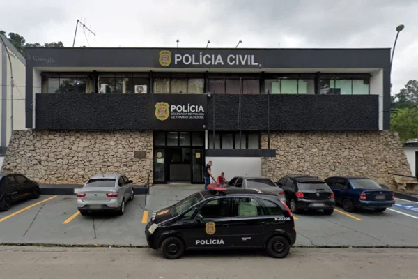Imagem colorida de fachada de delegacia com viatura preta estacionada na frente - Metrópoles