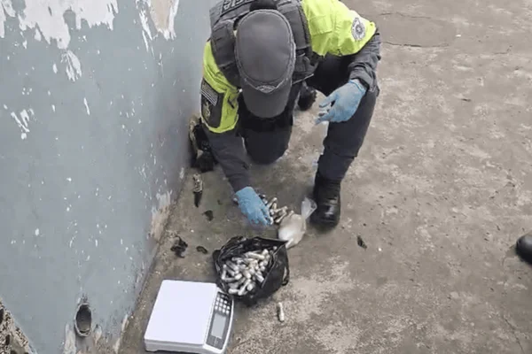 Imagem colorida de policial militar apreendendo cápsulas de cocaína durante abordagem - Metrópoles
