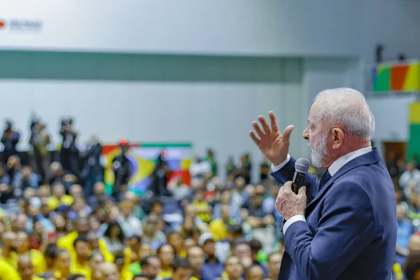 Imagens coloridas mostram o presidente Lula discursando para plateia ao fundo