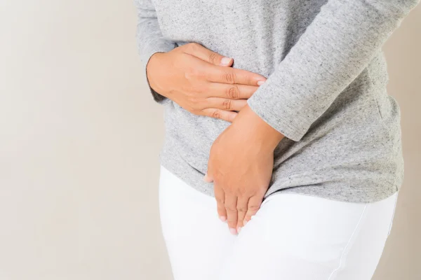 Mulher jovem com dor pressionando a virilha inferior do abdômen. Problemas médicos ou ginecológicos, conceito de assistência médica