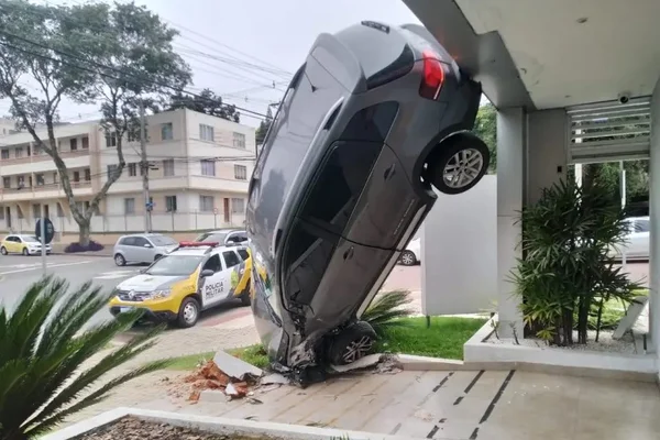 Foto colorida de carro pendurado em prédio em Curitiba - Metrópoles