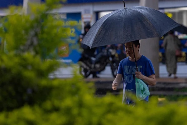 imagem colorida de pessoa com guarda-chuva em plena chuva