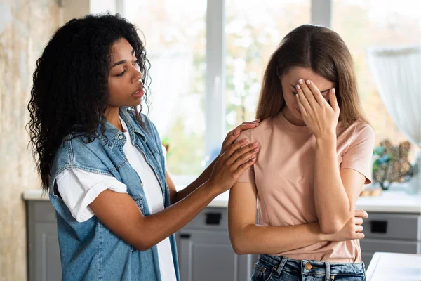 Mulher com as mãos na cabeça enquanto outra tenta acalmá-la. Sinais de uma amizade tóxica - Metrópoles