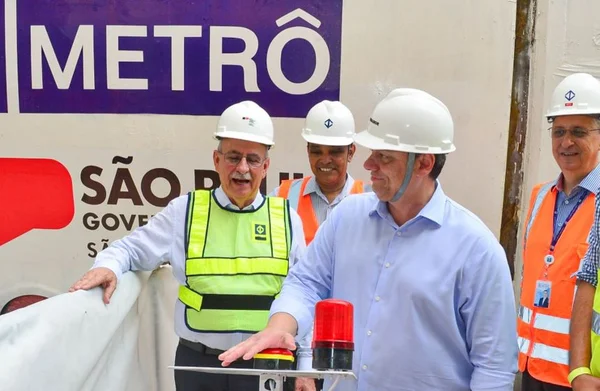 Foto colorida do governador Tarcísio de Freitas de camisa azul e capacete vistoriando as obras do metrô de SP - Metrópoles