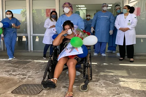 paciente da covid-19, em cadeira de rodas, chora na saída de hospital
