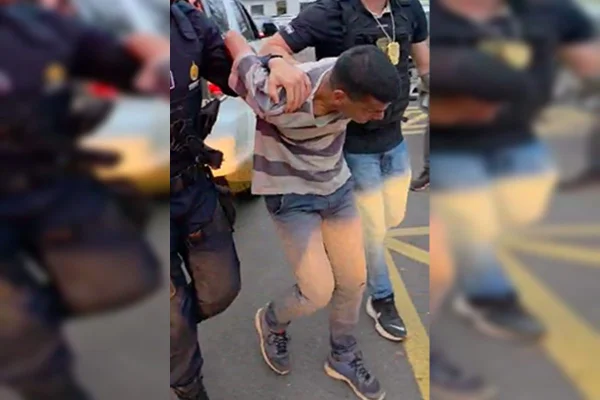 Foto de homem sendo levado à prisão