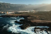 Costa vulcânica de Tenerife, nas Ilhas Canárias, Espanha, com formações rochosas escuras de lava encontrando o mar agitado Costa vulcânica de Tenerife, nas Ilhas Canárias, Espanha, com formações rochosas escuras de lava encontrando o mar agitado