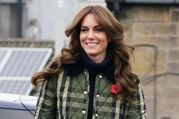Foto colorida de mulher com cabelo ondulado e casaco xadrez - Metrópoles