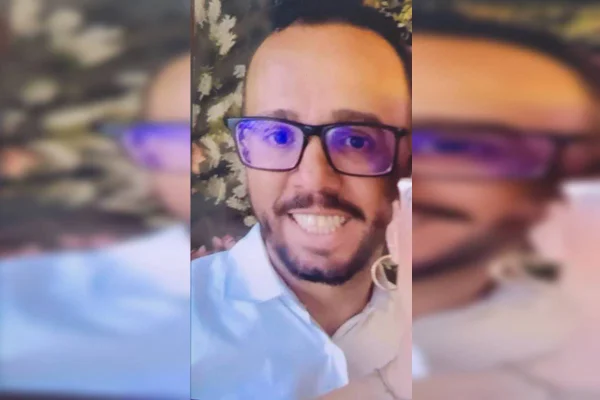 Foto colorida de homem branco com óculos