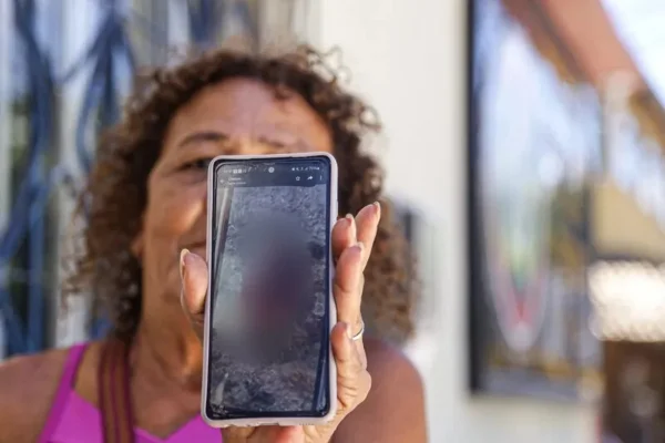 Mulher que teve a língua com o rosto tampado por um celular - Metrópoles