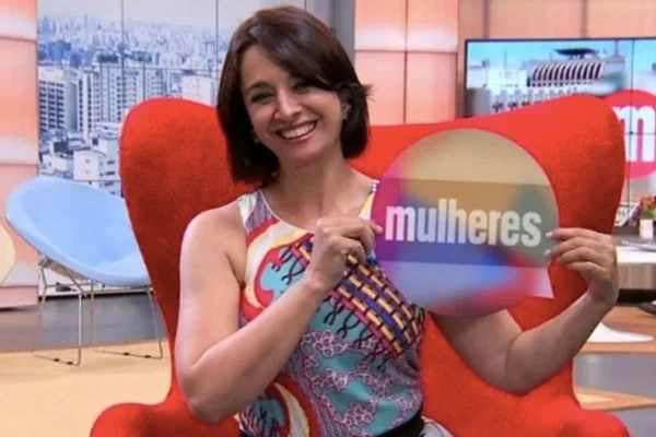 Foto colorida de Catia Fonseca segurando uma placa escrito "mulheres" - Metrópoles