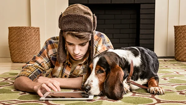 ser humano e cachorro mexendo em aparelho eletrônico