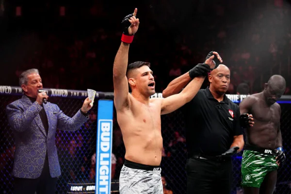 Vicente Luque tem braços erguidos após vitória sobre Themba Gorimbo do Zimbabwe no UFC 310 em Las Vegas, Nevada