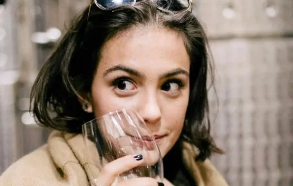 Valentina Cohen com uma taça na mão e óculos na cabeça - Metrópoles