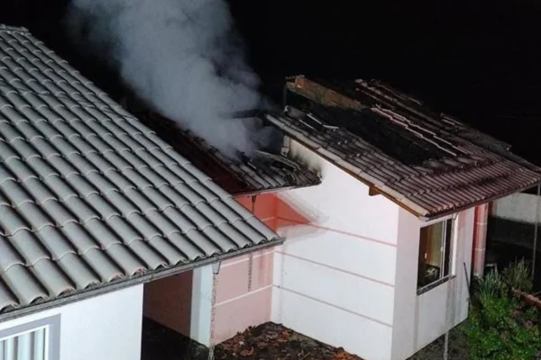 Imagem colorida de fumaça saindo de dentro de uma casa