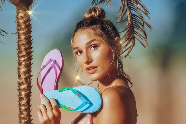Sasha Meneghel segurando chinelos em campanha da Melissa
