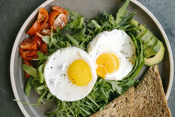 ovo frito posicionado em um prato de salada
