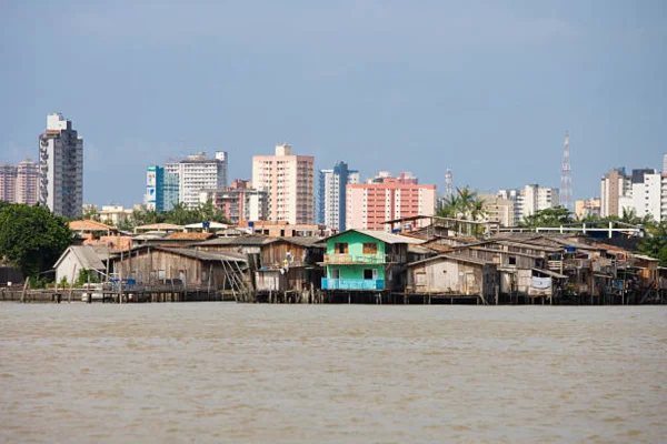 Vista panorâmica de Belém, com casas coloridas à beira do rio e pequenas embarcações ancoradas nas margens