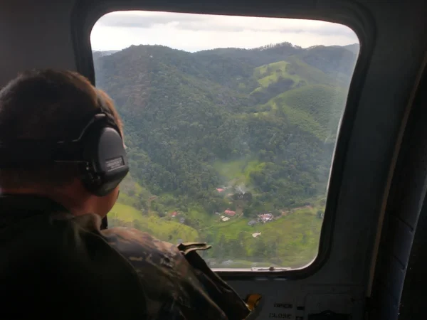 Imagem colorida mostra agente da FAB durante os trabalhos de buscas por helicóptero desaparecido em São Paulo; plano de resgate das vítimas deve ser cumprido com dia claro e tempo firme - Metrópoles
